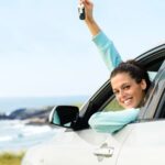 woman with keys in a car smiling car insurance icon